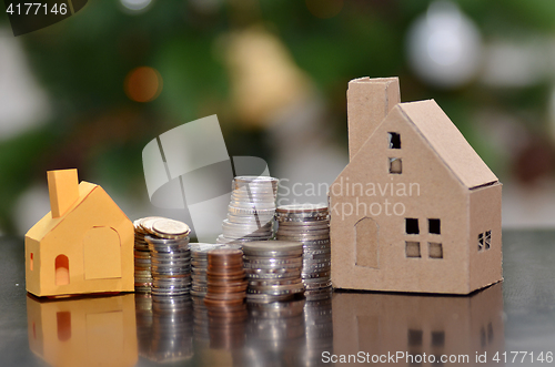 Image of Paper house and stacks of coins standing