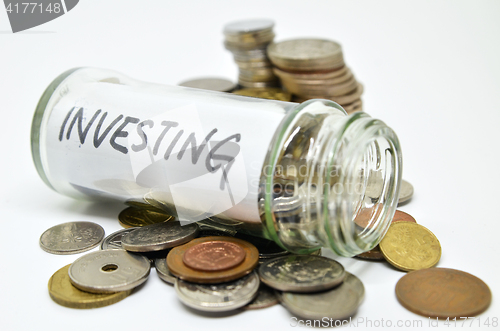 Image of Investment lable in a glass jar with coins spilling out