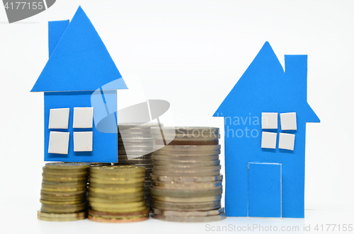 Image of House model and stacks of coins