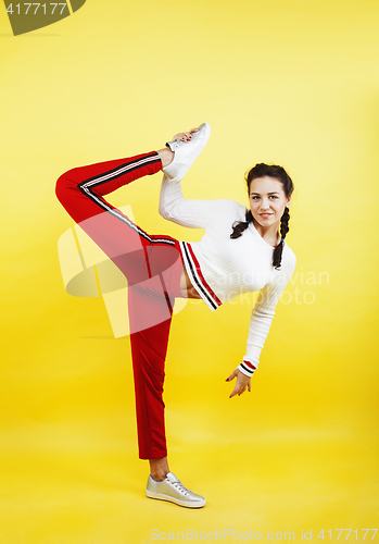 Image of young pretty teenage girl emotional posing on yellow background, fashion lifestyle people concept 
