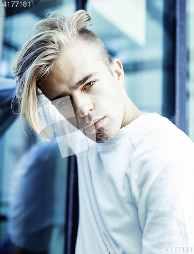 Image of young modern hipster guy at new building university blond fashion hairstyle having fun, lifestyle people concept 