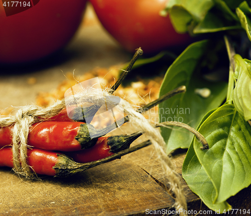 Image of vegetables on wooden kitchen with spicies, tomato, chilli, green