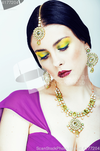 Image of young pretty caucasian woman like indian in ethnic jewelry close up on white, bridal bright makeup