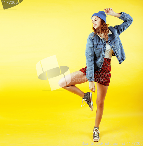 Image of young pretty teenage girl emotional posing on yellow background, fashion lifestyle people concept 