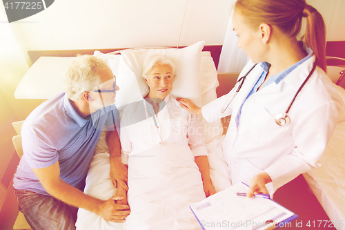 Image of senior woman and doctor with clipboard at hospital