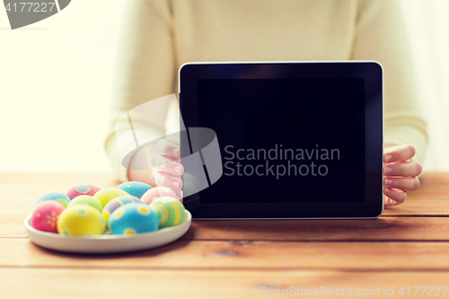 Image of close up of woman with tablet pc and easter eggs