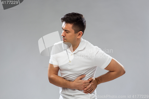 Image of unhappy man suffering from stomach ache