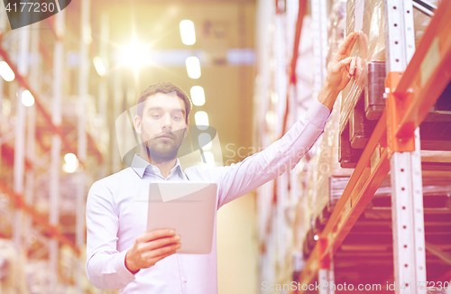 Image of businessman with tablet pc at warehouse