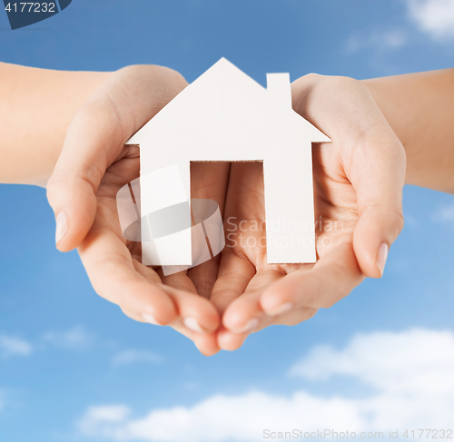 Image of close up of hands holding paper house