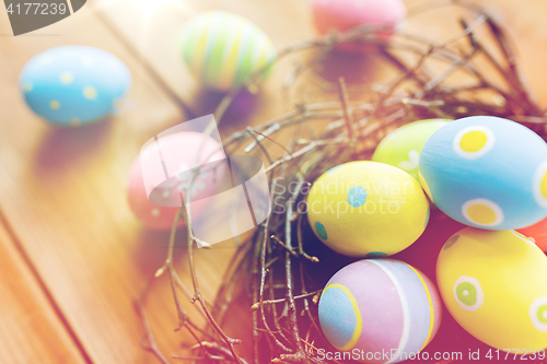 Image of close up of colored easter eggs in nest on wood