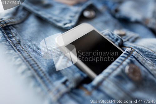 Image of smartphone in pocket of denim jacket or waistcoat