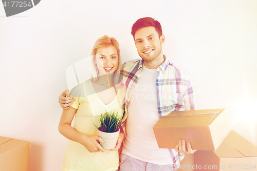 Image of smiling couple with big boxes moving to new home