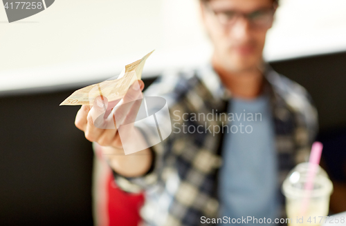 Image of happy man with cash money paying at cafe