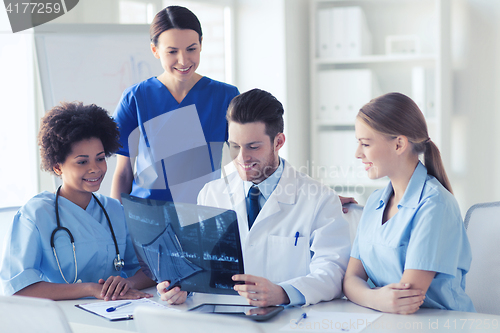 Image of group of happy doctors discussing x-ray image