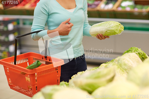 Image of woman with basket and chinese cabbage at grocery