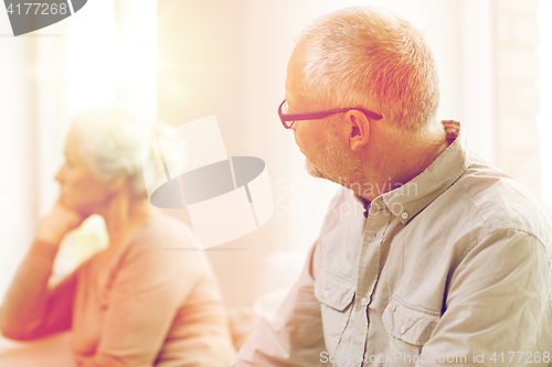 Image of senior couple sitting on sofa at home