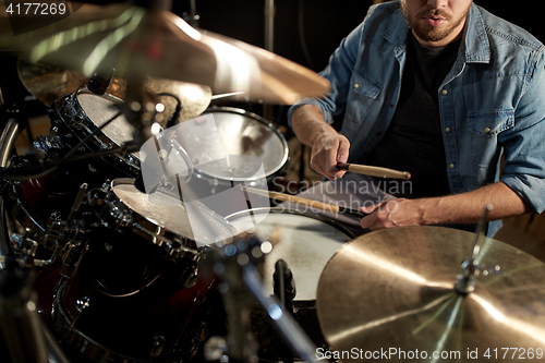 Image of male musician playing drums and cymbals at concert