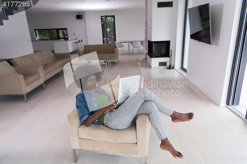 Image of African American women at home in the chair using a laptop