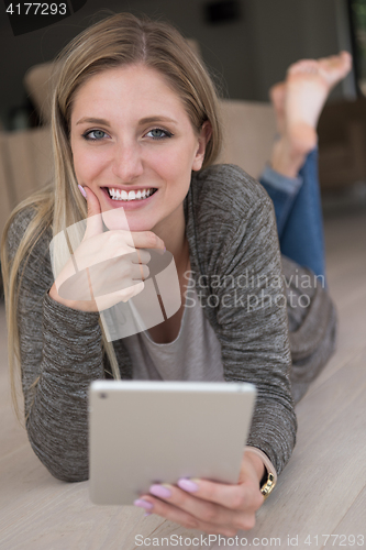 Image of young women used tablet computer on the floor