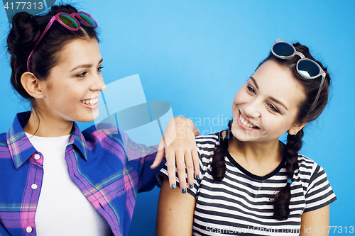 Image of best friends teenage girls together having fun, posing emotional on blue background, besties happy smiling, lifestyle people concept 