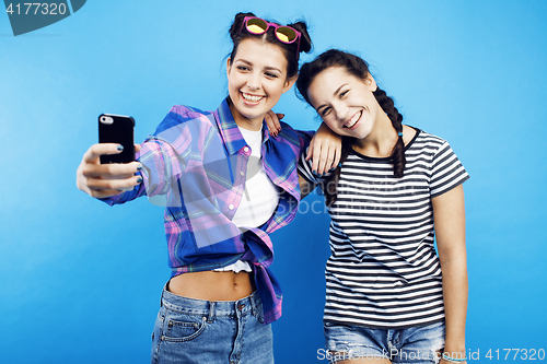 Image of best friends teenage girls together having fun, posing emotional on blue background, besties happy smiling, lifestyle people concept 