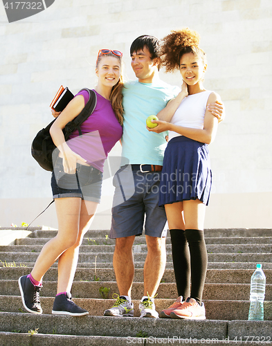 Image of cute group of teenages at the building of university with books 