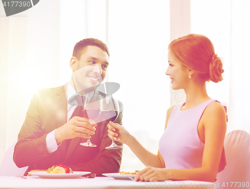 Image of couple with main course and red wine at restaurant