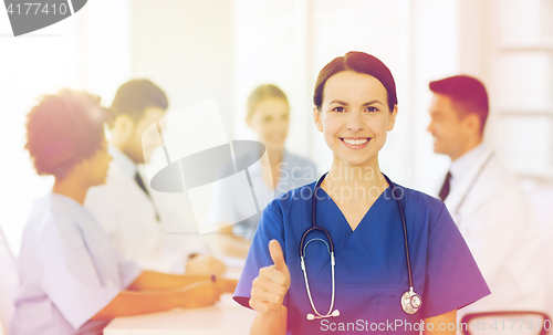 Image of happy doctor over group of medics at hospital