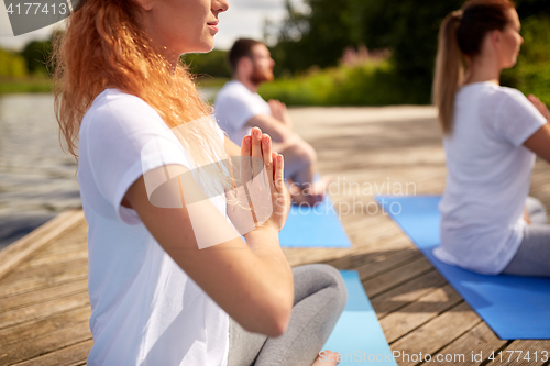 Image of close up of people making yoga exercises outdoors