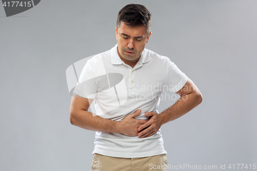 Image of unhappy man suffering from stomach ache