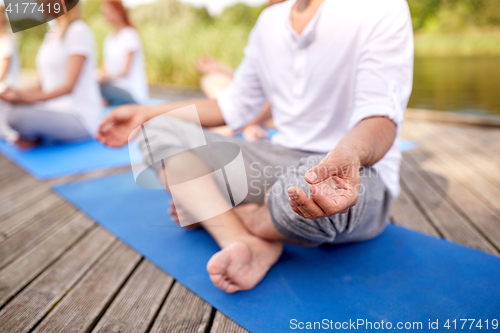 Image of close up of people making yoga exercises outdoors