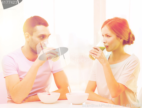 Image of smiling couple having breakfast at home