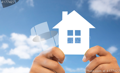 Image of close up of hands holding paper house