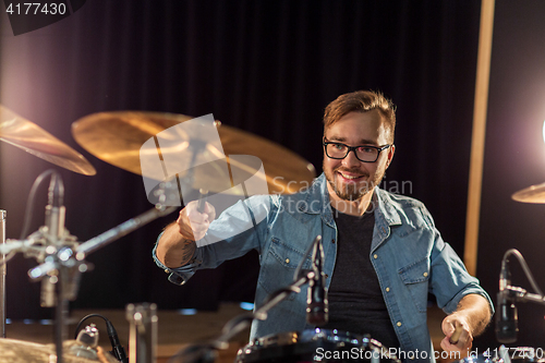 Image of male musician playing drums and cymbals at concert