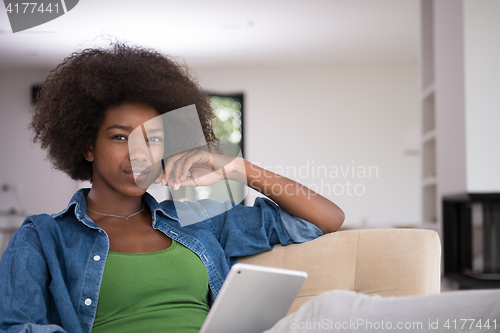 Image of african american woman at home with digital tablet