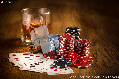 Image of Cigar, chips for gamblings, drink and playing cards