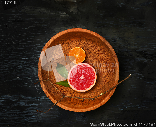 Image of Grapefruit citrus fruit halves on wooden plate