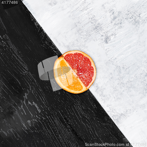 Image of Grapefruit and orange citrus fruit halves on wooden