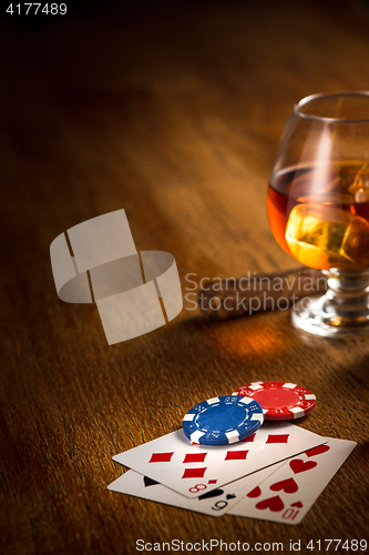 Image of Cigar, chips for gamblings, drink and playing cards