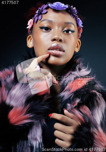 Image of young pretty african american woman in spotted fur coat and flowers jewelry on head smiling sweet etnic make up bright