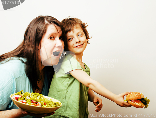 Image of fat woman holding salad and little cute boy with hamburger on white background