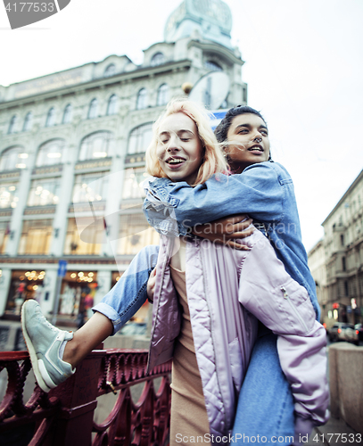 Image of Two teenage girls infront of university building smiling, having