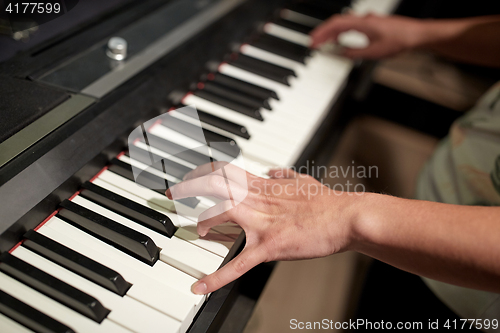 Image of close up of hands playing piano