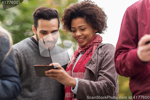 Image of happy friends with smartphone outdoors