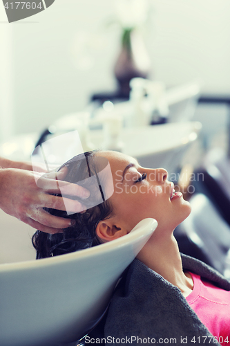 Image of happy young woman at hair salon