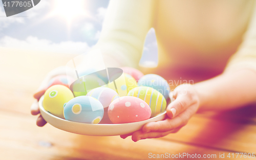 Image of close up of woman hands with colored easter eggs