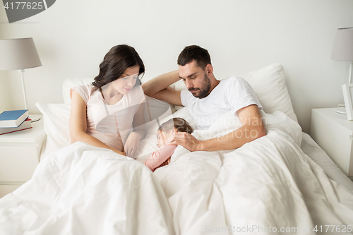 Image of happy family sleeping in bed at home