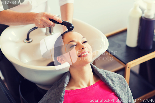 Image of happy young woman at hair salon