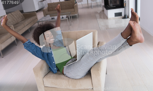 Image of African American women at home in the chair using a laptop