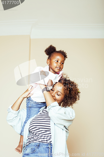 Image of adorable sweet young afro-american mother with cute little daughter, hanging at home, having fun playing smiling, lifestyle people concept, happy smiling modern family